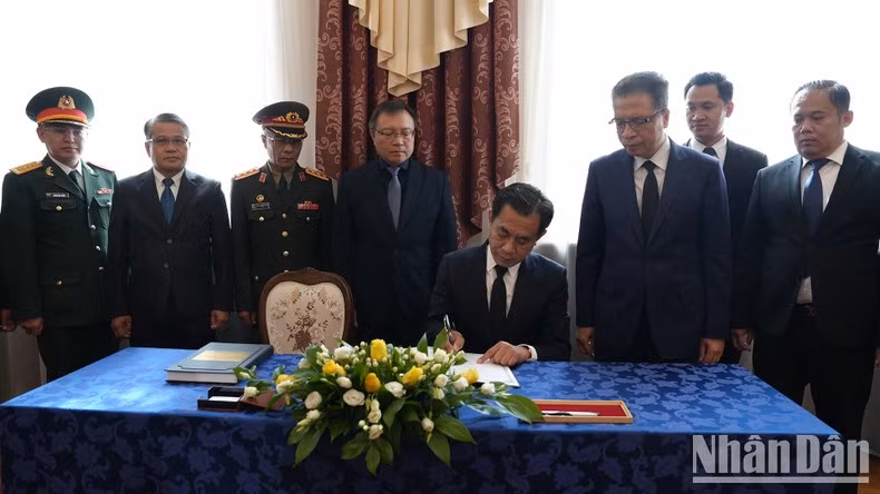 El representante de la delegación de la embajada de Laos en Rusia escribe el libro de condolencias.
