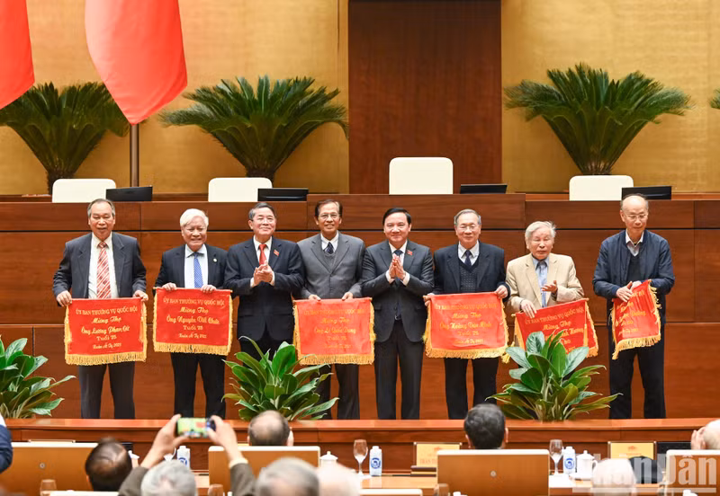 Los vicepresidentes de la ANV, Nguyen Khac Dinh y Nguyen Duc Hai, entregan pancartas de longevidad a los delegados jubilados.