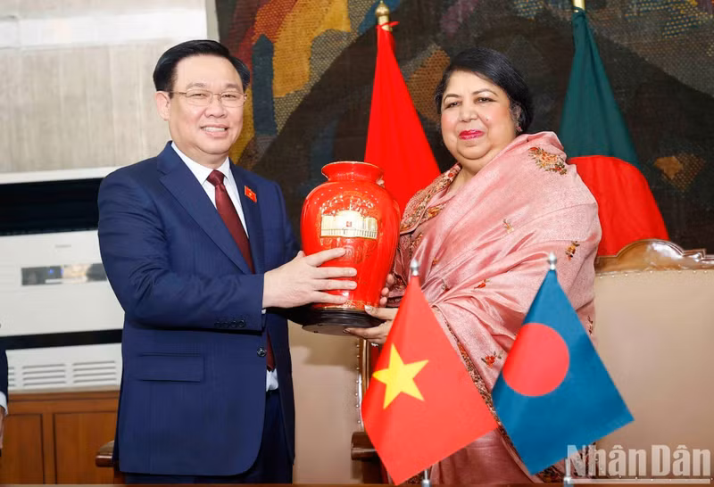 El presidente de la AN de Vietnam, Vuong Dinh Hue, entrega un recuerdo a su homóloga bangladeshí.