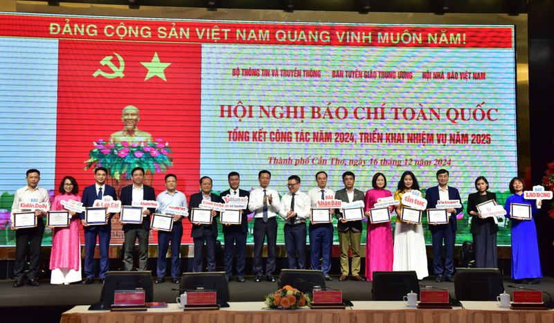 Le Quoc Minh, subjefe de la Comisión de Comunicación y Educación del Comité Central del Partido Comunista de Vietnam (PCV), presidente-editor del periódico Nhan Dan y titular de la Asociación de Periodistas del país, y Nguyen Manh Hung, subjefe de la Comisión de Comunicación y Educación del Comité Central del PCV, entrega certificados a las entidades que implementaron con excelencia en la transformación digital en el periodismo en 2024, en el marco de la Conferencia de Prensa Nacional 2024, celebrada hoy en la sureña ciudad de Can Tho.
