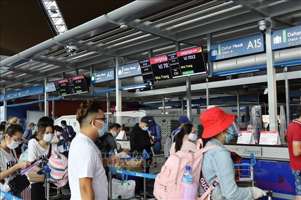 Ciudadanos vietnamitas, que trabajan en Malasia, esperan en fila para realizar procedimientos aduaneros. (Foto de VNA)