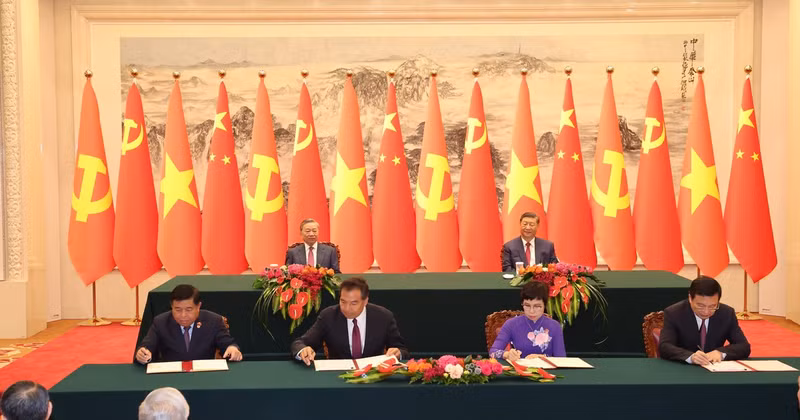 Ceremonia de firma del Acuerdo de Cooperación entre la Agencia Vietnamita de Noticias y la Agencia de Noticias Xinhua (derecha) y la cooperación en materia de inversiones (izquierda) entre los dos países. (Foto: VNA)