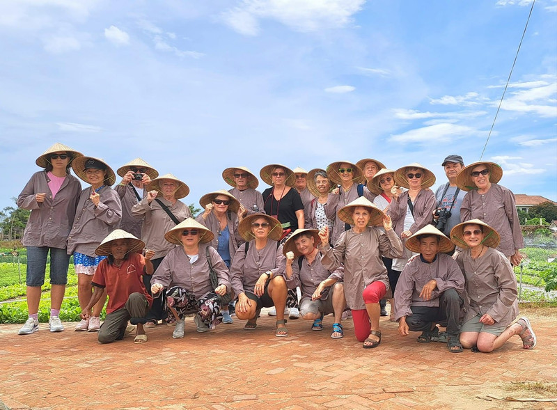 Turistas españoles toman foto de recuerdo en la aldea de cultivo de verduras de Tra Que, el 19 de agosto de 2023. 