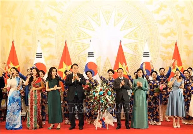 Los dos presidentes y sus esposas entregan flores a artistas. (Fuente:VNA)