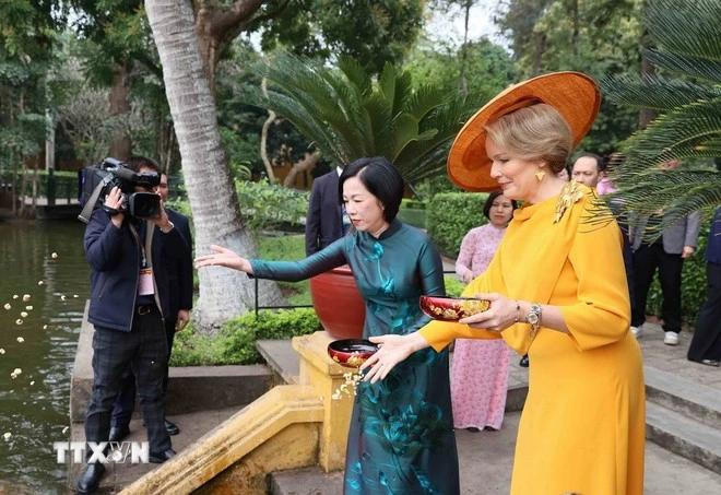 Nguyen Thi Minh Nguyet, esposa del presidente Luong Cuong, y la reina Matilde de Bélgica, alimentan a los peces en el estanque de Tío Ho, en el sitio de reliquias del Presidente Ho Chi Minh. (Foto: VNA)