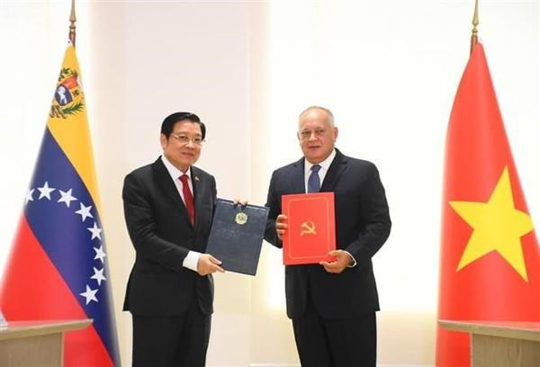 El secretario del Comité Central del PCV y jefe de su Comisión de Asuntos Internos Phan Dinh Trac, y el primer vicepresidente del PSUV, Diosdado Cabello, firman un acuerdo de cooperación entre el PCV y el PSUV. (Foto: VNA)