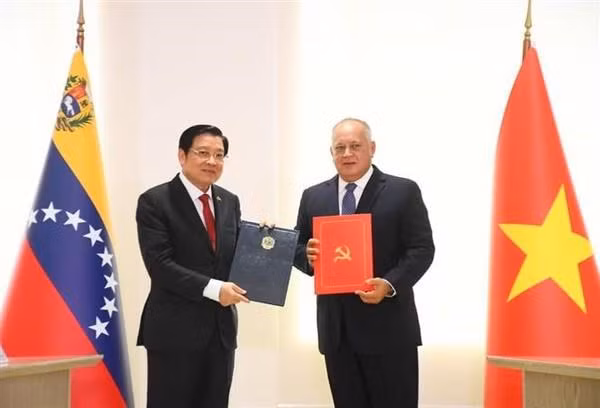 El secretario del Comité Central del PCV y jefe de su Comisión de Asuntos Internos Phan Dinh Trac, y el primer vicepresidente del PSUV, Diosdado Cabello, firman un acuerdo de cooperación entre el PCV y el PSUV. (Foto: VNA)