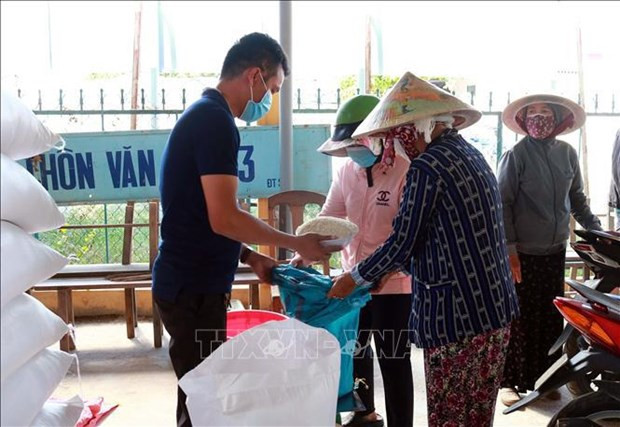 Entrega de arroz a los pobladores. (Foto: VNA)