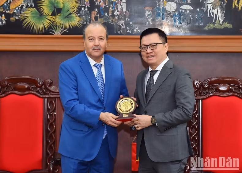 El presidente-editor de Nhan Dan, Le Quoc Minh, regala el logotipo de su periódico al embajador Abdelhamid Boubazine.