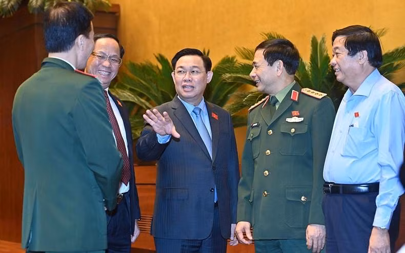 El presidente de la Asamblea Nacional, Vuong Dinh Hue, y los otros delegados al margen de la sesión de debate sobre el proyecto de Ley de Defensa Civil.