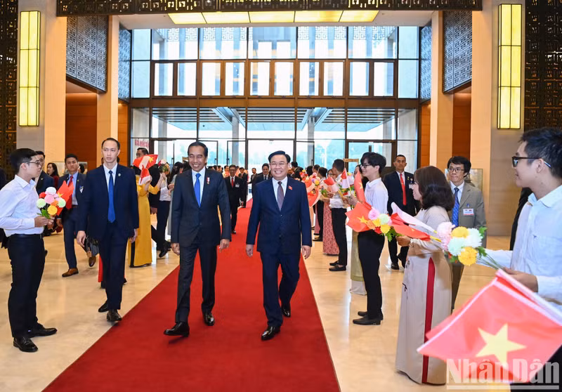 El presidente de la ANV, Vuong Dinh Hue, y el mandatario indonesio, Joko Widodo.