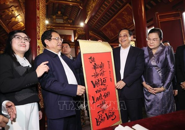 El primer ministro de Vietnam, Pham Minh Chinh, obsequia una caligrafía con palabras vietnamitas a su homólogo laosiano, Sonexay Siphandone. (Foto: VNA)