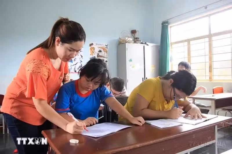 Una clase exclusiva para los niños damnificados por el agente naranja, dada por la profesora H'Khuin en la provincia de Gia Lai. (Foto: VNA)