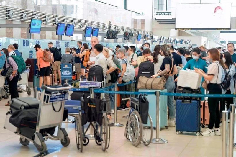 Los pasajeros realizan los procedimientos para sus vuelos en el Aeropuerto Internacional de Noi Bai. (Foto: VNA)