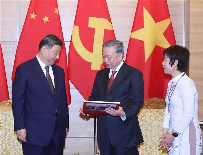 El secretario general del Partido Comunista de Vietnam, To Lam, entrega respetuosamente al secretario general del Partido Comunista y presidente de China, Xi Jinping, un libro de fotografías de la Agencia de Noticias de Vietnam, que incluye fotos típicas e impresionantes de las cinco visitas de Xi Jinping al país indochino. (Foto: VNA)