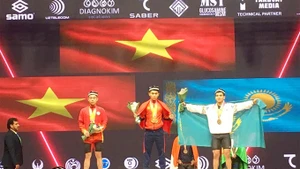 El pesista vietnamita K'Duong en el podio recibiendo la medalla de oro. (Fotografía: qdnd.vn)