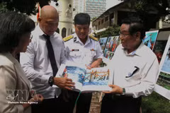 El fotógrafo Nguyen A presenta el libro "Historias sobre el mar e islas de la Patria" a los visitantes de la exposición. (Foto: VNA)