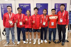 Los atletas de teqball Trinh Gia Nghi y Nguyen Hoang Minh Tan (tercero y cuarto desde la izquierda) con miembros del cuerpo técnico tras ganar una medalla de bronce en los XX Juegos Asiáticos. (Foto: VNA)