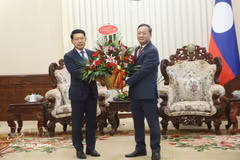 El embajador de Vietnam en Laos, Nguyen Minh Tam, transmite el arreglo floral de felicitación del primer ministro vietnamita Le Minh Hung al premier laosiano Saleumxay Kommasith. (Foto: VNA)