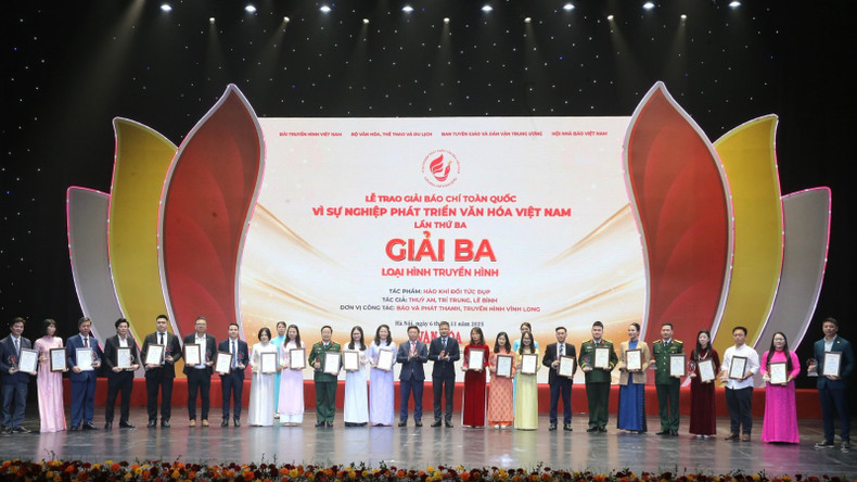 Tran Thanh Lam, subjefe de la Comisión de Propaganda y Movilización de Masas del Comité Central del Partido, y Do Duc Hoang, vicedirector general de la Televisión Nacional de Vietnam, felicitan a los ganadores del tercer premio.
