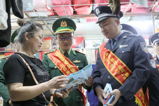 Las fuerzas fronterizas de Vietnam y China divulgan la legislación fronteriza entre los comerciantes en el mercado de Tan Thanh en Lang Son. (Foto: VNA)