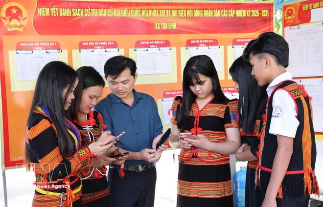 Los habitantes de Xo Dang (comuna de Tra Linh, ciudad de Da Nang) ven vídeos e infografías en sus teléfonos que les guían sobre cómo votar. (Foto: VNA)