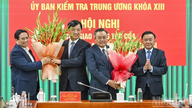 El primer ministro Pham Minh Chinh y el permanente del Secretariado del PCV, Tran Cam Tu, entregan flores para felicitar al secretario del Comité del Partido de Hanói, Nguyen Duy Ngoc, y al jefe de la Comisión de Control Disciplinario del Comité Central del PCV, Tran Sy Thanh.