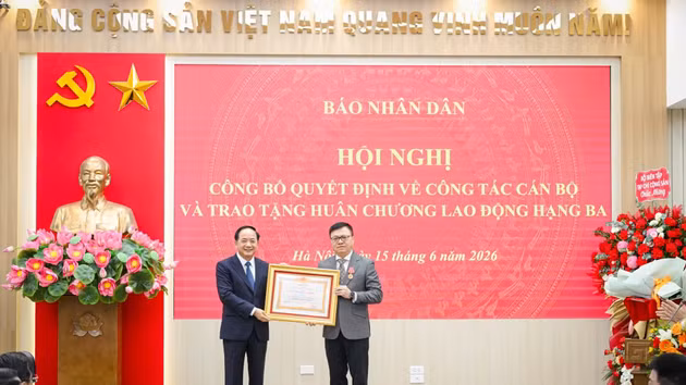 Trinh Van Quyet, miembro del Buró Político, secretario del Comité Central del Partido Comunista y jefe de la Comisión de Propaganda y Movilización de Masas del Comité Central, entrega la Orden del Trabajo de Tercera Clase al presidente-editor del periódico Nhan Dan, Le Quoc Minh.