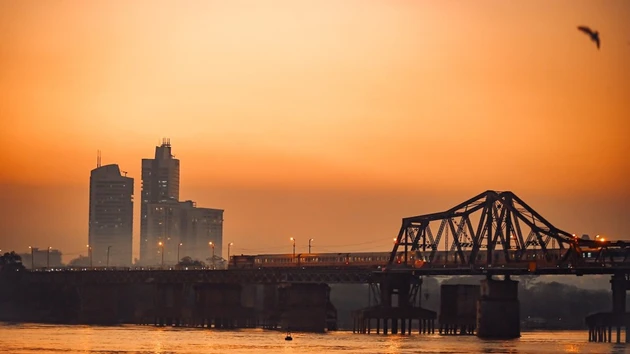 Desde la distancia, se puede contemplar el puente Long Bien, donde el atardecer tiñe el agua de carmesí mientras un tren avanza lentamente hacia el corazón de la ciudad. (Foto: Vietnam+)