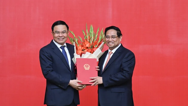 El primer ministro de Vietnam, Pham Minh Chinh, entrega la decisión de nombrar a Le Manh Hung, como ministro interino de Industria y Comercio.