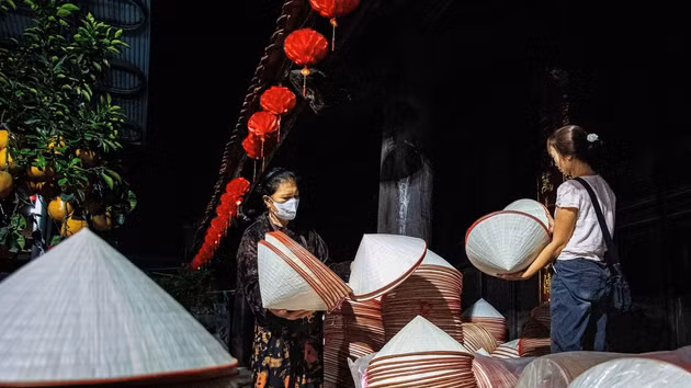 En el mercado, los aldeanos llevan montones de sombreros cónicos a la plaza del pueblo para venderlos. (Foto: VNA)