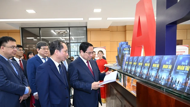 El primer ministro Pham Minh Chinh y delegados visitan el área expositiva sobre los libros y las actividades de la academia.