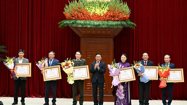 El integrante del Buró Político y miembro permanente del Secretariado del Comité Central del Partido Comunista de Vietnam, Tran Cam Tu, entrega la Orden del Trabajo de Primera Clase a las agencias con aportes excepcionales a la labor de asesoría, organización y servicio durante el XIV Congreso Nacional del Partido. 