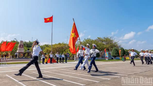 Despliegue del protocolo del orden cerrado bajo la bandera de la Patria, junto al mojón que marca la soberanía vietnamita en la isla de Truong Sa.