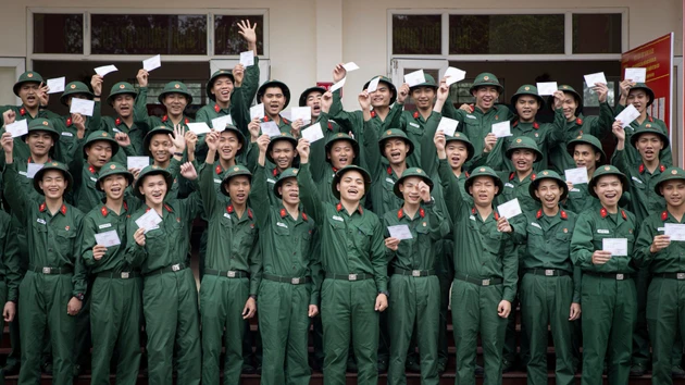 Los nuevos reclutas del Pelotón 14 de la Compañía 15 (Batallón 4, Brigada 144, Estado Mayor General del Ejército Popular de Vietnam), regocijados al sostener sus papeletas de votación para las próximas elecciones generales.