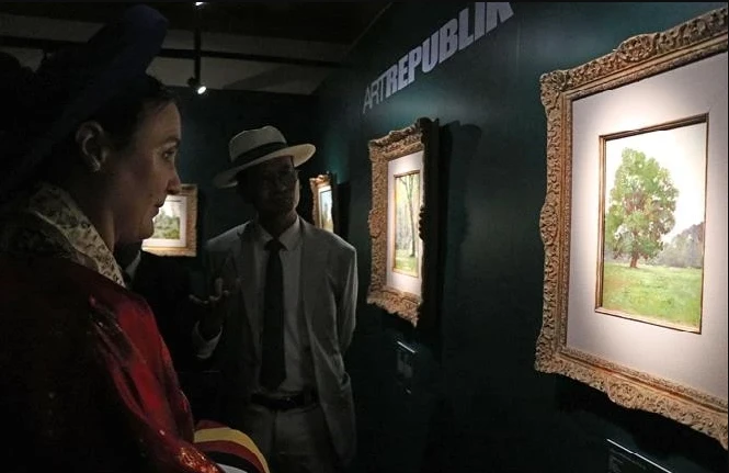 La audiencia contempla las pinturas en la exposición. (Fotografía: VNA)