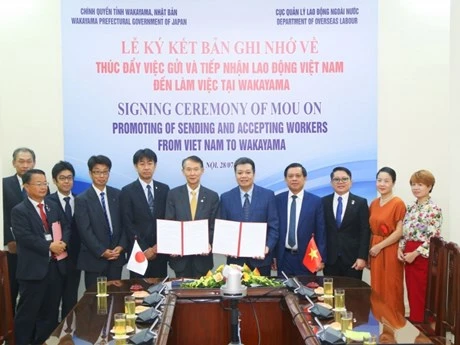 Nguyen Ba Hoan, viceministro de Trabajo, Inválidos de Guerra y Asuntos Sociales de Vietnam, y el gobernador de la prefectura japonesa de Wakayama, Kishimoto Shuhei, presencian el acto de firma del memorándum de entendimiento. (Foto: VNA)
