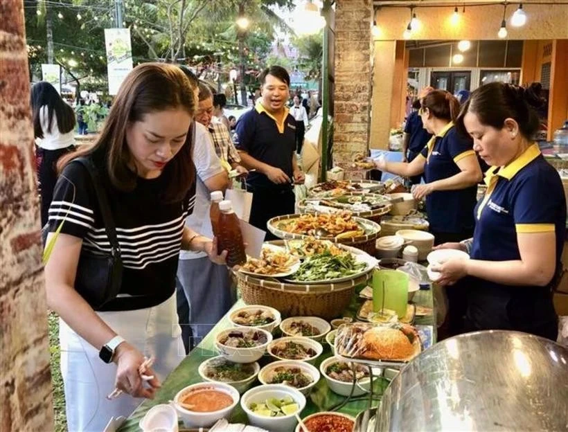 Los visitantes degustan los platos en el festival. (Foto: VNA)
