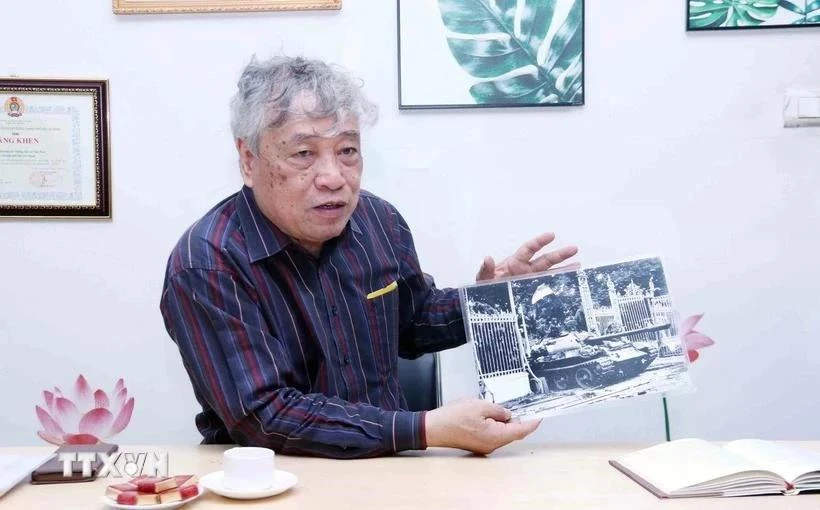El periodista Tran Mai Huong con la foto titulada "El tanque del Ejército de Liberación entra al Palacio de Independencia al mediodía del 30 de abril de 1975". (Fotografía: VNA)