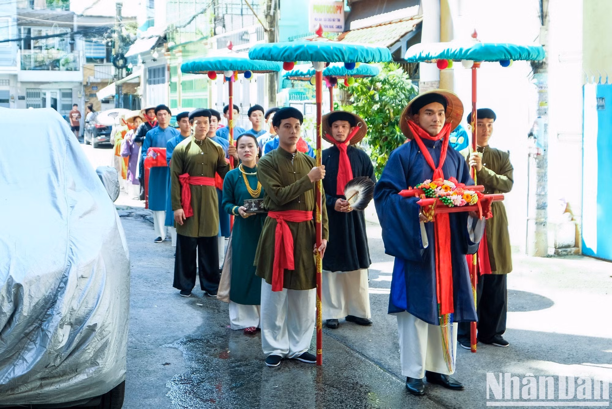 Representantes de la familia del novio, ataviados con trajes tradicionales, llevan a la casa de la novia bandejas de ofrendas con hojas de betel y nueces de areca, té, licor y otros presentes.