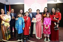 El primer ministro Pham Minh Chinh y su esposa otorgan libros en idioma vietnamita a la comunidad de residentes vietnamitas en Estonia. (Foto: VNA) 