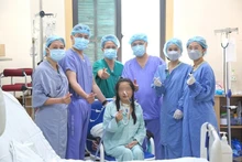 Médicos del Hospital de Amistad Vietnam-Alemania posan junto con la paciente que recibió el primer trasplante simultáneo de corazón y pulmón en Vietnam. (Foto: Hospital de Amistad Vietnam-Alemania)