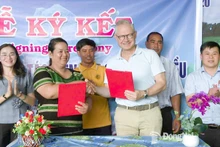 Thi Khui, directora de la Cooperativa Agrícola de Anacardo Orgánico Trang Co Bu Lach, firma un acuerdo de cooperación un representante de la empresa Intersnack Vietnam. (Foto: Periódico Dong Nai)