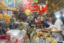 Turistas extranjeros eligen productos artesanales en Ciudad Ho Chi Minh para comprar como recuerdo. (Foto: VNA)