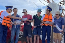 Las fuerzas encargadas de hacer cumplir la ley marítima difunden información sobre la pesca INDNR entre los pescadores. (Foto: VNA)