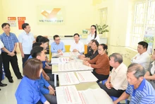 La delegación de Nhan Dan y la Corporación de Correos de Vietnam se reúne con pobladores de la comuna de Hong Nam, en la provincia de Hung Yen.