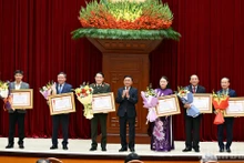 El integrante del Buró Político y miembro permanente del Secretariado del Comité Central del Partido Comunista de Vietnam, Tran Cam Tu, entrega la Orden del Trabajo de Primera Clase a las agencias con aportes excepcionales a la labor de asesoría, organización y servicio durante el XIV Congreso Nacional del Partido. 