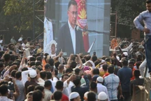 Multitudes siguen la ceremonia de investidura del nuevo primer ministro de Gobierno bangladesí, Tarique Rahman, transmitida en vivo desde el Edificio del Parlamento Nacional, en Daca, la capital, el 17 de febrero de 2026. (Foto: Xinhua)