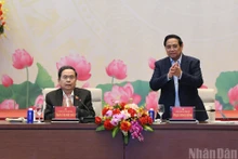 El secretario del Comité del Partido Comunista de Vietnam en el Gobierno y primer ministro, Pham Minh Chinh (de pie), y el secretario del Comité del Partido en la Asamblea Nacional y presidente de esta entidad, Tran Thanh Man, conducen la conferencia.