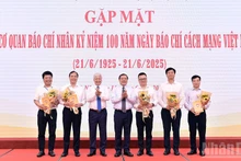 El presidente del Comité Central del Frente de la Patria de Vietnam, Do Van Chien y el subjefe de su Comisión de Propaganda y Movilización de Masas del Partido, Lai Xuan Mon (3º y 4º a la izquierda) entregan flores a los representantes los medios en el evento.
